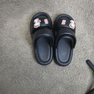 Peanuts Snoopy slide sandals with Syracuse “S” logo and Peanuts branding. Black
